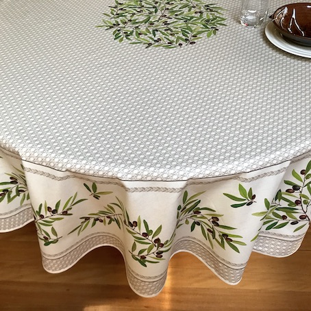 large round coated tablecloth from provence with olives designs on a beige background