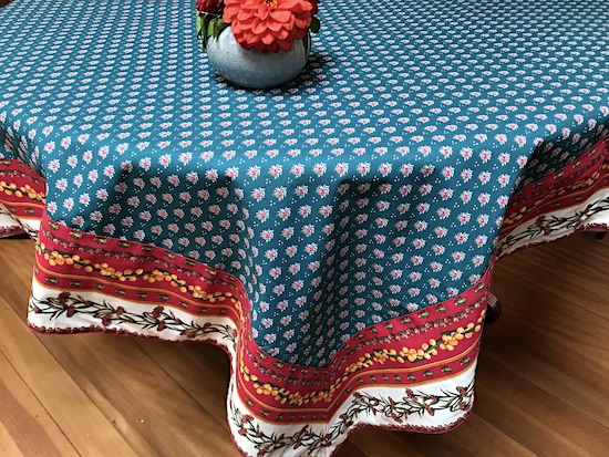 french provencal green cotton tablecloth with a contrasting red border wth mitred corners